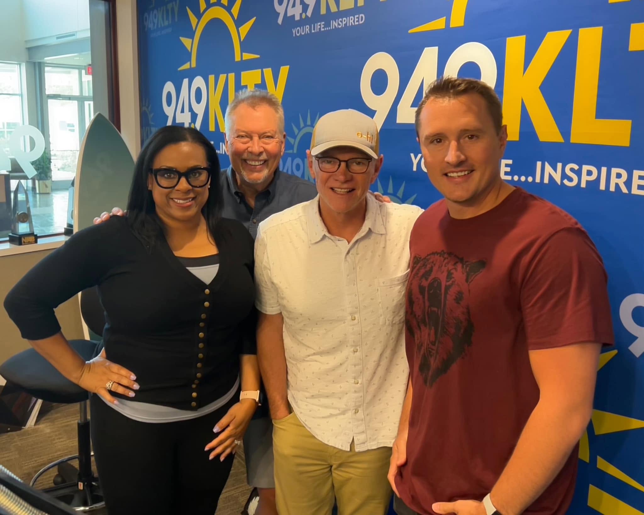Frank Reed with a group in front of a 94.9 KLTY backdrop
